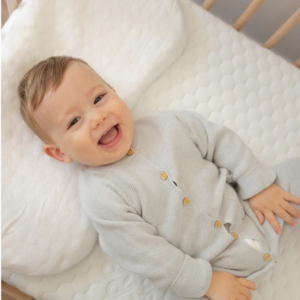 Primer plano de la suave tela exterior de la almohada antiplagiocefalia Care, mostrando su textura transpirable.