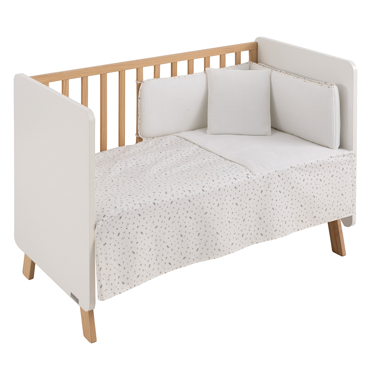Conjunto textil de cuna de tres piezas de la colección Minimal Gris de Cambrass, que incluye un edredon acolchado con diseño elegante, un protector o chichonera a juego para proteger los barrotes de la cuna y un cojín decorativo infantil en tonos grises.